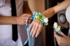 Groom helps wearing flower bracelet